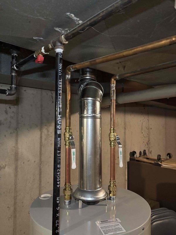 Successfully installed a 40-gallon natural gas water heater in the basement utility area. The installation included a Bradford White tall model unit with proper venting through a metallic vent pipe system, copper supply lines with brass shut-off valves and compression fittings on both the hot and cold water sides, and all required labeling and safety compliance stickers. The unit was positioned on a stable concrete floor against the foundation wall with adequate clearance for service access and proper connection to existing gas and water supply lines.