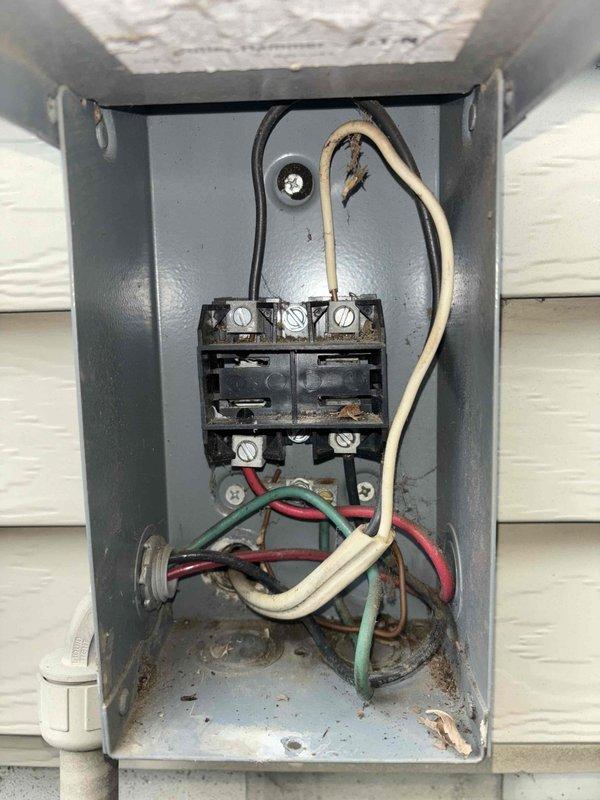 Completed annual cooling maintenance on 10-year-old air conditioning system. Performed comprehensive inspection of outdoor condensing unit, including electrical disconnect enclosure which showed age-appropriate weathering and minor corrosion on interior surfaces and terminal screws. Verified all electrical connections at disconnect, noting older cloth-insulated wiring in serviceable condition. Inspected unit's internal electrical components including capacitor and associated wiring, confirmed high voltage warning label present on access panel. All electrical connections tested secure, system operational. Documented equipment condition with photographs for service records.