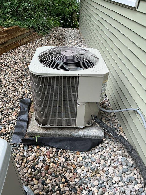 Responded to service request to disconnect 5-year-old Payne air conditioning system for repair. Upon arrival, confirmed unit was still operational and cooling properly. Performed electrical disconnect at outdoor condenser unit to safely isolate system for upcoming repair work. Inspected condenser coils and exterior components during service call. Condenser unit located on concrete pad with proper clearances, equipped with standard disconnect box mounted on exterior wall. Documented equipment condition with photos showing unit positioned on landscaping rock bed with refrigerant lines properly insulated. System ready for scheduled repair service once disconnected.