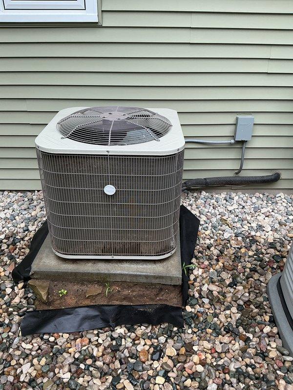 Responded to service request to disconnect 5-year-old Payne air conditioning system for repair. Upon arrival, confirmed unit was still operational and cooling properly. Performed electrical disconnect at outdoor condenser unit to safely isolate system for upcoming repair work. Inspected condenser coils and exterior components during service call. Condenser unit located on concrete pad with proper clearances, equipped with standard disconnect box mounted on exterior wall. Documented equipment condition with photos showing unit positioned on landscaping rock bed with refrigerant lines properly insulated. System ready for scheduled repair service once disconnected.