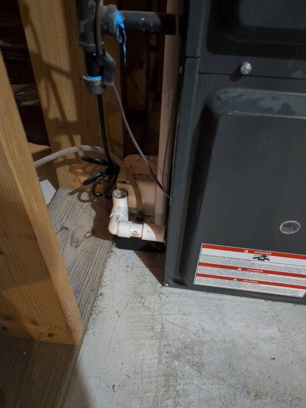 Completed annual cooling maintenance on a 9-year-old air conditioning system. Performed comprehensive tune-up procedures including system inspection, cleaning, and performance verification. Documented equipment condition and installation with photographs showing the HVAC unit in the basement mechanical room along with associated plumbing and electrical components.