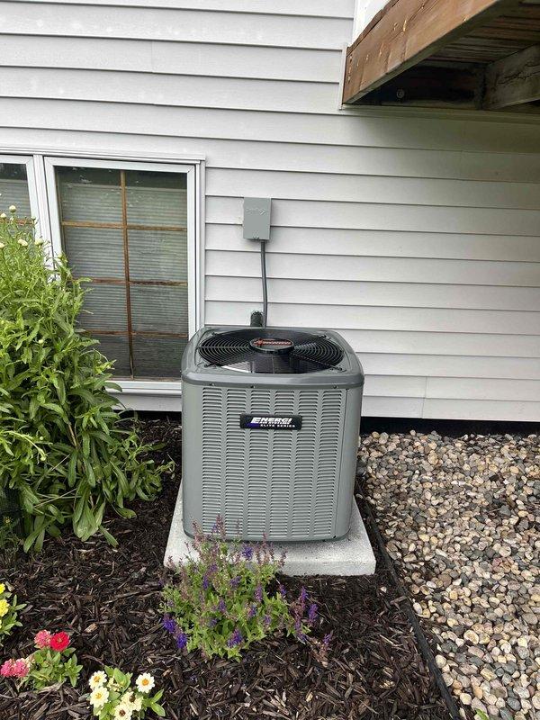 Completed full air conditioning system replacement at residential property. Removed existing outdoor condensing unit and installed new gray outdoor HVAC condenser on concrete pad with proper clearances and landscaping considerations. Indoor installation included new American Standard air handler unit positioned above existing furnace in basement utility area. Established refrigerant line connections using copper lines with proper insulation, secured all ductwork transitions with metallic flex duct, and verified electrical conduit connections to exterior unit. System startup performed with operational checks confirming proper airflow, refrigerant charge, and equipment function across all components.