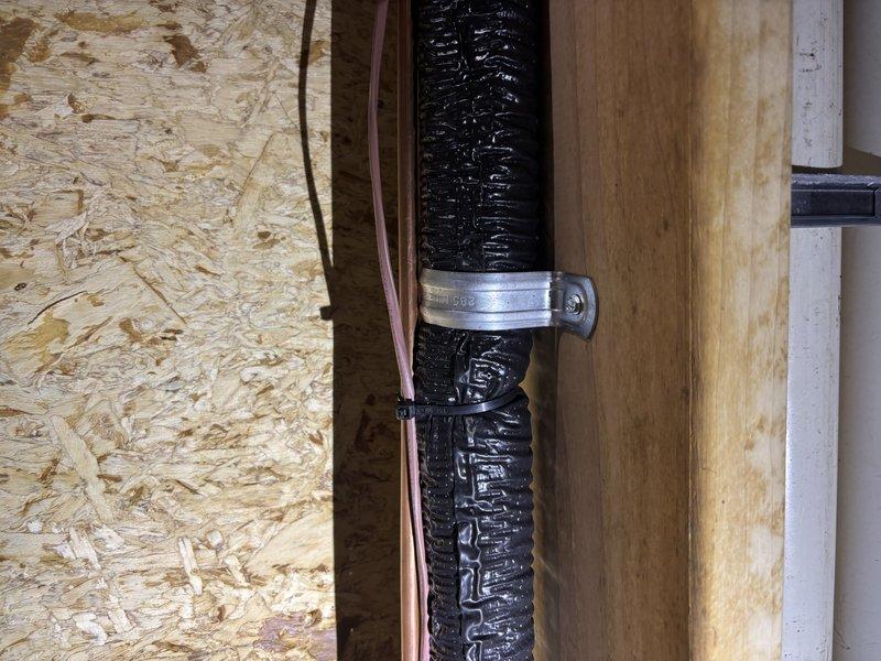 Responded to customer complaint of loud banging noise from outside AC unit upon startup. Inspected exterior condensing unit and traced refrigerant lines into attic space. Found inadequately secured suction line creating vibration and impact noise against floor joists when compressor engaged. Repositioned and properly secured copper refrigerant line and associated flex duct using appropriate mounting straps and clamps to eliminate contact with structural framing members. Cycled system multiple times to verify noise elimination and proper operation.