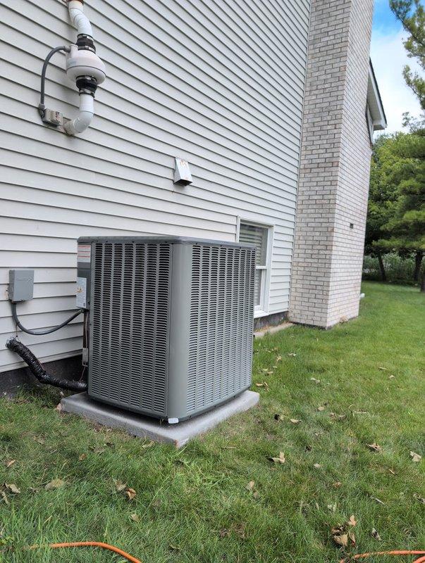 Completed full air conditioning system replacement at residential property. Removed existing outdoor condenser unit and installed new dual-zone HVAC condenser system on concrete pad against exterior wall with proper electrical connections and refrigerant line routing. Installed new indoor air handler unit in basement mechanical room, integrated with existing furnace system. Connected flexible and rigid ductwork throughout basement ceiling space, ensuring proper airflow distribution. Installed and configured white PVC condensate drainage lines from air handler to existing plumbing system. Mounted and wired humidifier unit to HVAC system for climate control integration. Verified all electrical connections, refrigerant charge levels, and system pressures meet manufacturer specifications. Tested complete system operation including cooling cycles, thermostat response, and airflow measurements at all registers. All equipment secured, labeled, and operational per industry standards.