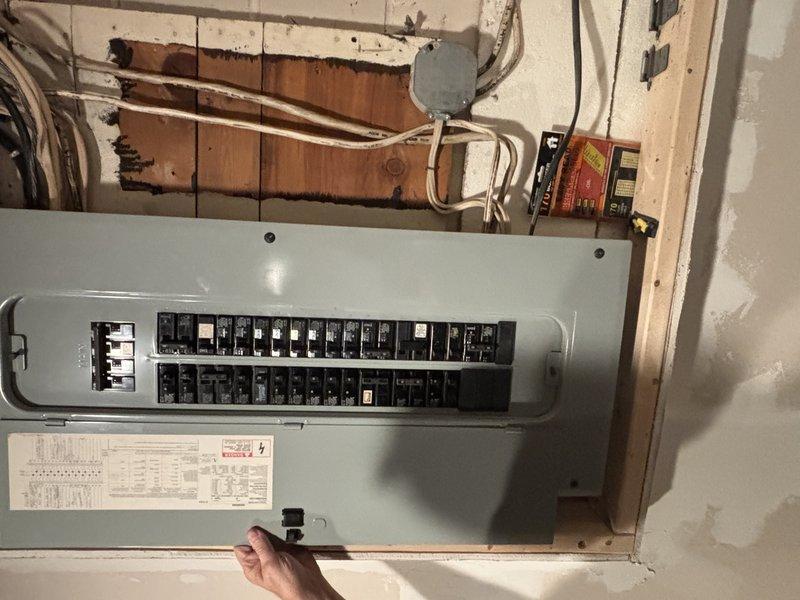 Provided estimate for water heater replacement in unfinished basement utility area. Assessed existing residential water heater installation with copper piping configuration, shutoff valves, and connections to electrical panel. Evaluated surrounding conditions including exposed wooden framing with evidence of previous water damage or staining, electrical panel with circuit breakers, conduit routing, and plumbing infrastructure to determine scope of replacement work and necessary modifications to bring installation up to current code requirements.