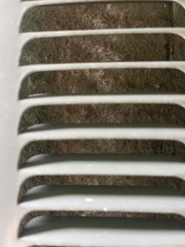 Completed annual cooling system tune-up and preventive maintenance inspection. Documented significant dust and debris accumulation on interior ventilation grilles and return air vents, photographed HVAC equipment exterior showing condensation on condenser unit housing and louvered panels with minor dirt buildup. System operational at time of service completion.