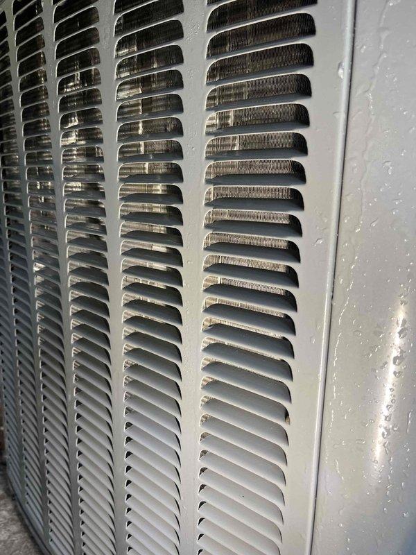 Completed annual cooling system tune-up and preventive maintenance inspection. Documented significant dust and debris accumulation on interior ventilation grilles and return air vents, photographed HVAC equipment exterior showing condensation on condenser unit housing and louvered panels with minor dirt buildup. System operational at time of service completion.