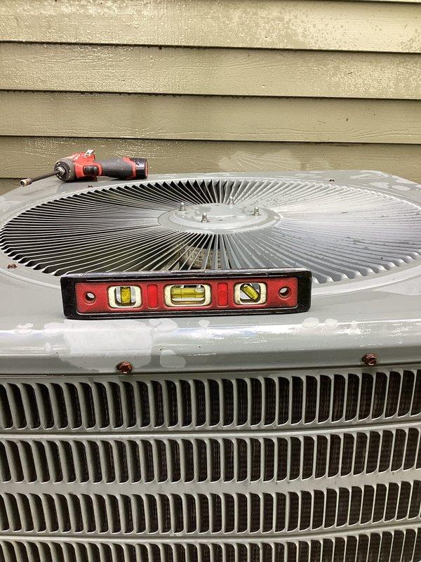 Completed annual cooling maintenance on 8-year-old residential air conditioning system. Performed comprehensive tune-up including inspection of outdoor condenser unit, verified proper level placement of equipment, and assessed mechanical components. Inspected heat exchanger coils showing clean vertical fins in good condition. Evaluated utility area plumbing connections, PVC drainage lines, and copper fittings for proper operation. Unit positioned on concrete pad with adequate clearance. System operational and ready for cooling season. Equipment warranty extends through December 2027.