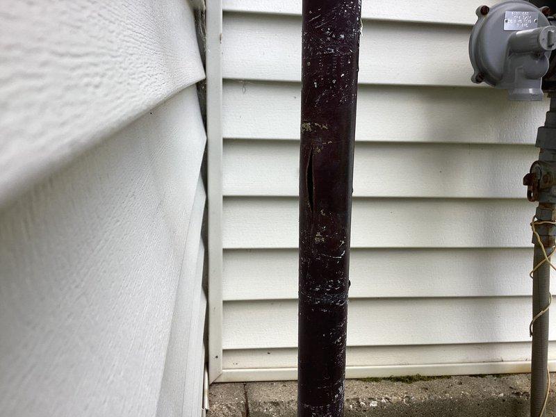 Responded to plumbing leak at 22-year-old residential property where issue began one day prior. Upon inspection, located broken pipe at exterior ball valve assembly mounted on building exterior near utility meter. Valve showed significant weathering, corrosion, and age-related deterioration with rust visible at stem connection point. Repaired/replaced damaged section and verified proper valve operation. Documented conditions with photographs showing exterior plumbing configuration, valve assembly with 600 WP rating markings, and connection points against vinyl siding. Confirmed repair resolved active leak and restored system integrity.