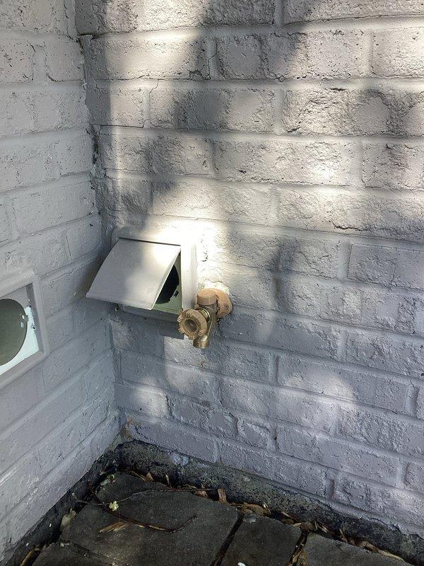 Replaced two exterior hose bibs in basement area of 1960s-era residential structure that had been experiencing operational issues for approximately five years. Successfully installed new brass spigot fixtures on white painted brick exterior wall, ensuring proper sealing and functionality. Documented completed installation with photographic evidence showing both the basement access point and exterior-mounted water supply connection.
