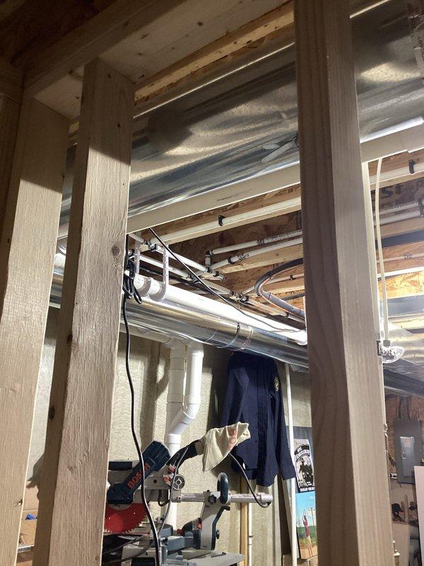 Conducted on-site evaluation for installation of new half bathroom in unfinished basement of 8-year-old residential property. Assessed existing plumbing infrastructure, including visible PVC drainage lines and supply piping within exposed wooden framing structure. Documented current HVAC ductwork routing and structural framing configuration to determine optimal fixture placement and required rough-in connections. Evaluated basement layout and existing utility locations to develop comprehensive estimate for toilet, sink, and associated drain-waste-vent system installation in accordance with local plumbing codes.
