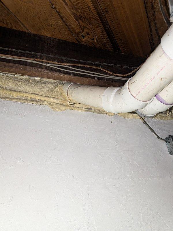 Completed water heater replacement estimate for a residential property with a 7-year-old existing unit located in a crawl space. Assessed current plumbing configuration including aged copper piping with visible oxidation, PVC drainage lines, and existing pump system. Documented installation area conditions, spray foam insulation at floor-wall junctions, and accessibility for replacement unit installation.
