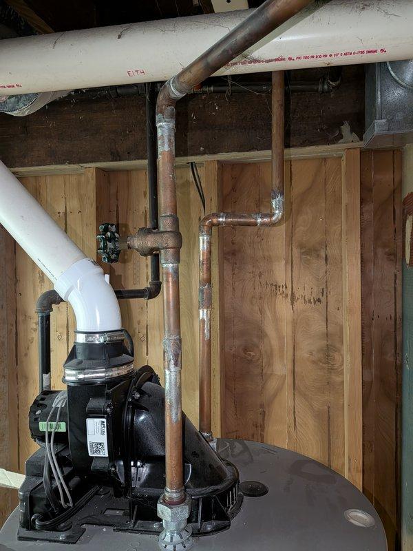 Completed water heater replacement estimate for a residential property with a 7-year-old existing unit located in a crawl space. Assessed current plumbing configuration including aged copper piping with visible oxidation, PVC drainage lines, and existing pump system. Documented installation area conditions, spray foam insulation at floor-wall junctions, and accessibility for replacement unit installation.