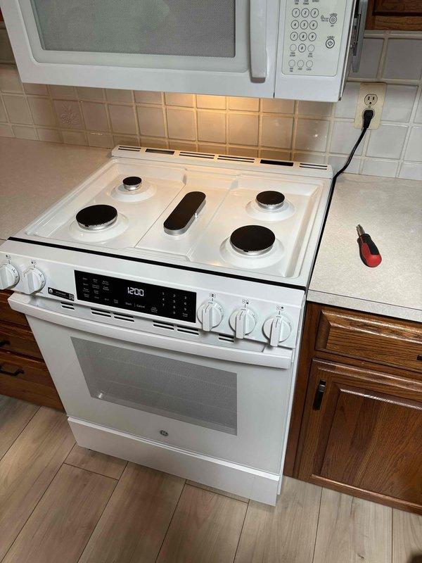 Completed QUOTR-quoted repair involving gas line installation for electric range conversion. Installed new gas supply line with black iron pipe and brass ball valve with shutoff capability, properly secured between floor joists in basement/crawl space area. Range successfully connected and operational with all burners and oven functioning as designed.