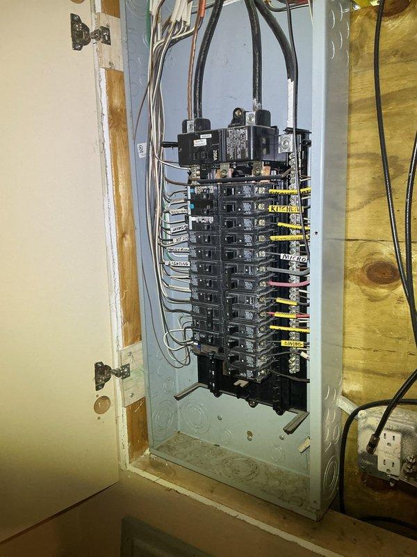 Completed electrical estimate for EV charging outlet installation at a 20-year-old residential property. Assessed existing electrical panel in unfinished basement area, noting adequate space availability with multiple circuit breaker positions and confirming panel capacity for additional 240V circuit required for Level 2 EV charging. Documented current electrical infrastructure including main breaker assembly, existing circuit distribution, and available conduit routing paths through basement joists and framing for new dedicated circuit installation.