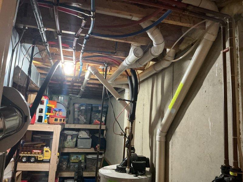 Completed electrical estimate for EV charging outlet installation at a 20-year-old residential property. Assessed existing electrical panel in unfinished basement area, noting adequate space availability with multiple circuit breaker positions and confirming panel capacity for additional 240V circuit required for Level 2 EV charging. Documented current electrical infrastructure including main breaker assembly, existing circuit distribution, and available conduit routing paths through basement joists and framing for new dedicated circuit installation.