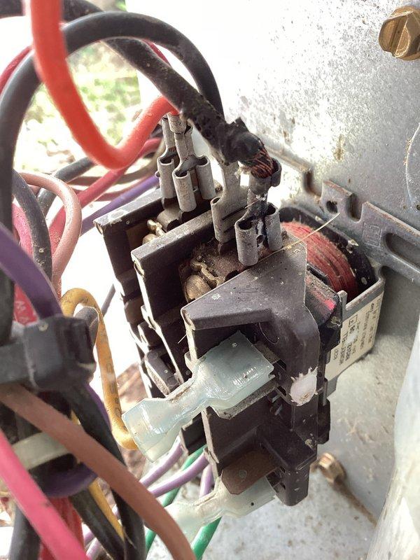 Completed annual cooling maintenance on 23-year-old Aireflo air conditioning system. Performed comprehensive inspection of outdoor condenser unit, which showed significant age-related wear with accumulated dirt and debris on protective mesh cage and components. Inspected electrical contactor and relay assembly, noting weathered condition with visible dust accumulation on terminals and connections. Verified all wire connections at contactor including multiple colored leads to terminal blocks were secure. Checked capacitor and associated electrical components for proper operation. Cleaned condenser coil and removed debris from unit exterior and surrounding area. Tested system operation and confirmed proper cooling function. Unit operational despite advanced age, though customer advised of system condition and potential need for future replacement consideration given equipment age and visible component deterioration.