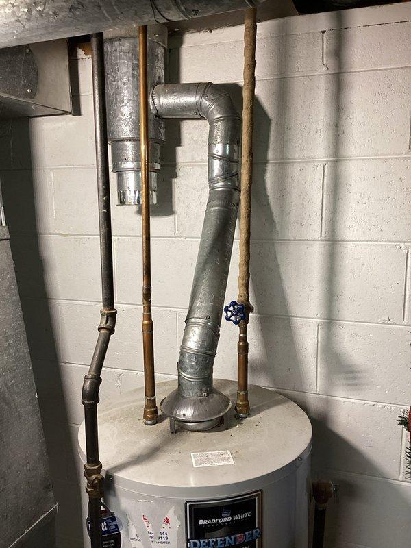 Successfully installed a Bradford White 40-gallon tall natural draft water heater in basement utility area. Connected all supply and discharge plumbing lines with copper piping, installed proper draft hood and venting through existing flue system, and verified all connections for proper operation. Blue isolation valve installed on cold water supply line, and unit tested to ensure safe and efficient operation per manufacturer specifications.