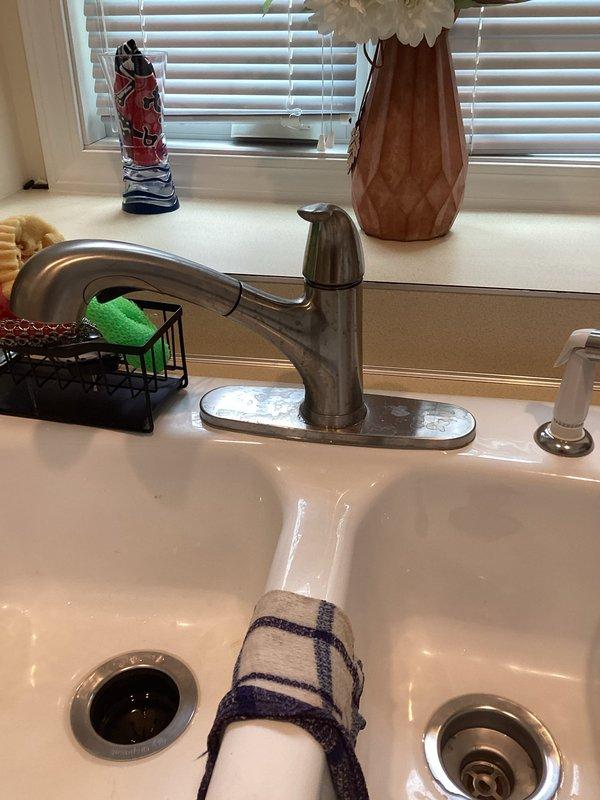Responded to kitchen cabinet leak beneath double-basin sink. Upon inspection, identified moisture issue in cabinet base and installed absorbent pads to protect cabinet floor while addressing plumbing concerns. Inspected PVC P-trap assembly, drain connections, and garbage disposal unit for potential leak sources. Verified all pipe connections were secure and properly sealed. Photographed plumbing configuration and cabinet conditions for documentation purposes. System tested and monitored to ensure proper drainage function and confirm leak resolution.