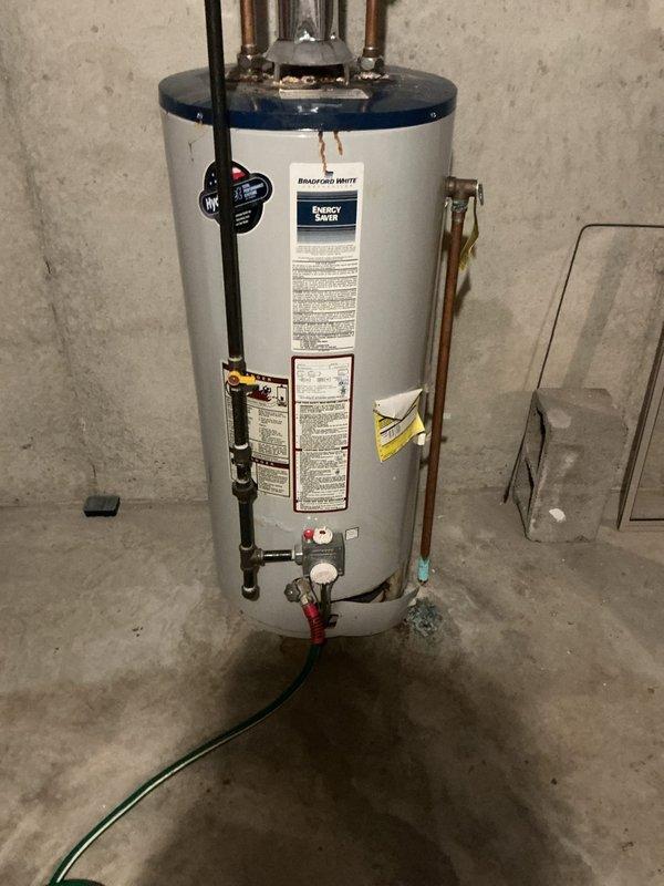 Completed installation of a 50-gallon Bradford White natural gas water heater in basement utility area. Unit was installed with proper copper supply line connections, gas line hookup, temperature and pressure relief valve, and all required safety controls per manufacturer specifications and local code requirements.