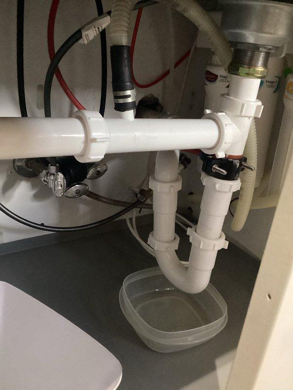 Reattached kitchen sink and reconnected plumbing assembly following countertop replacement. Reinstalled P-trap drainage system, garbage disposal connections, and water supply lines, ensuring all fittings were properly secured and leak-free. Verified proper operation of all components upon completion.