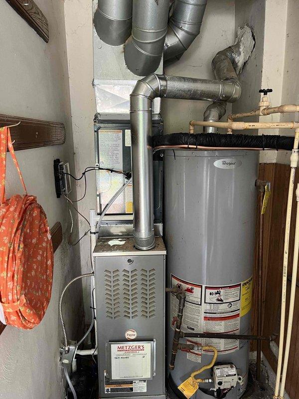 Completed full air conditioning system replacement at residential property. Removed existing AC unit and installed new cylindrical condenser unit on concrete pad against exterior wall with proper clearances. Ran new black flexible conduit along exterior wall to electrical disconnect box, securing all lines with appropriate mounting brackets. System startup performed, verified proper refrigerant charge, electrical connections, and airflow. All components tested and operational within manufacturer specifications.