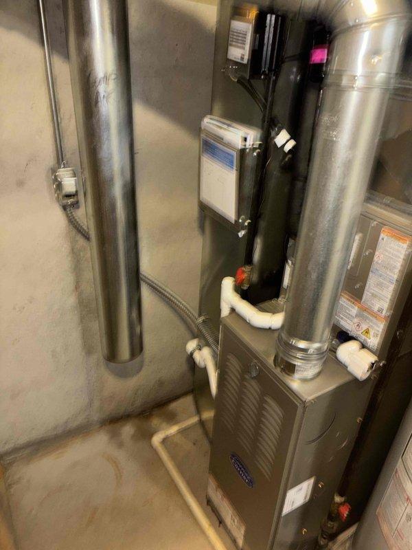 Completed full HVAC system installation including new furnace and air conditioning unit. Installed gray furnace in mechanical room with proper PVC condensate drainage and intake/exhaust piping, connected to galvanized metal ductwork with flexible couplings, and mounted all necessary electrical controls and components. Installed Payne brand outdoor condenser unit on concrete pad with proper gravel base, ran electrical conduit through exterior wall, and verified all connections for proper system operation.