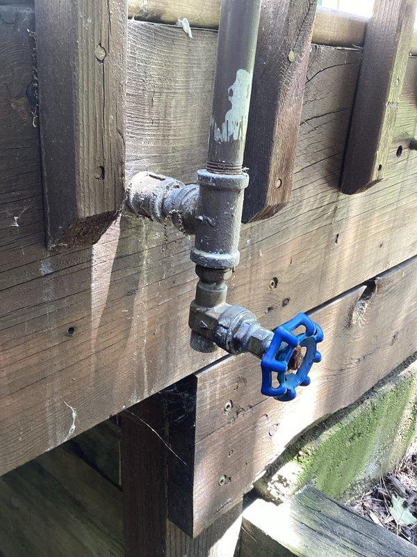 Responded to outdoor faucet leak that had been present since May, affecting both the exterior hose bib and interior shutoff valve. Accessed the interior shutoff valve located in the attic/ceiling space and replaced the defective blue-handled gate valve with new fixture. Replaced the outdoor faucet assembly mounted on the exterior fence, including new threaded connections and galvanized pipe fittings to eliminate the leak at the source. Tested both interior shutoff valve and exterior faucet for proper operation and verified no additional leaks in the system upon completion.