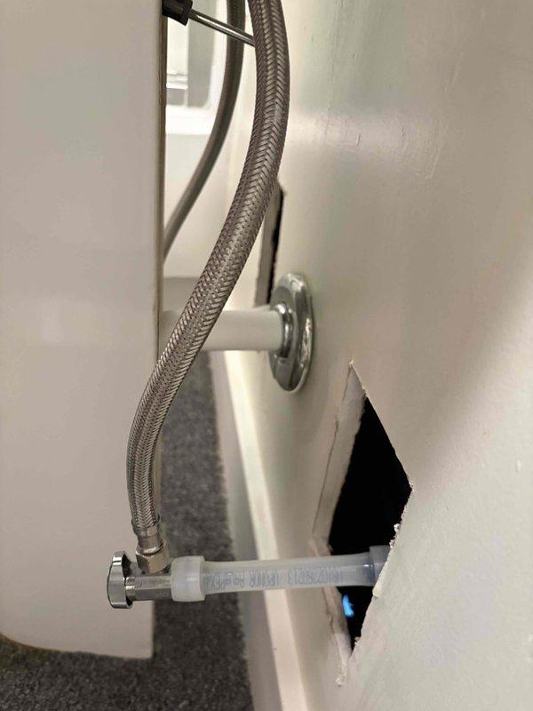 Responded to service call regarding protruding water supply lines that were preventing drywall repair completion. Cut down previously installed service lines by 6 inches to bring them flush with wall framing, allowing drywall contractor to proceed with repairs. Verified braided stainless steel flexible supply lines and chrome valve fittings remained properly secured and functional after modification.