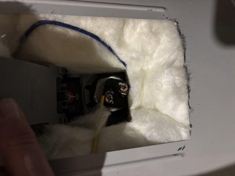 Completed warranty repair work on electrical outlet junction box. Replaced damaged elements and properly installed insulation around electrical connections, ensuring all wiring terminals and connections were secure and code-compliant. Verified proper installation of electrical components with appropriate fiberglass insulation placement around the recessed junction box cavity.
