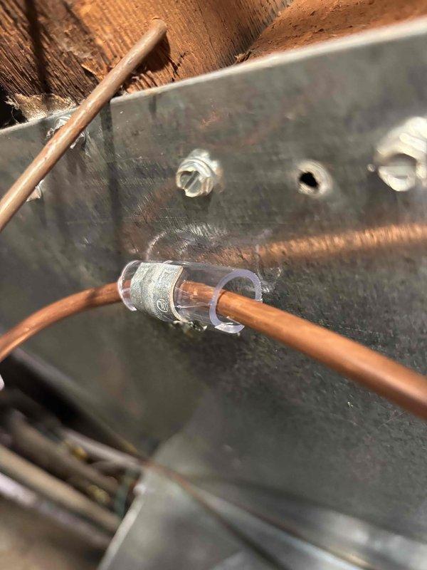 Completed inspection corrections for HVAC system following partial approval notice. Addressed three code violations: repositioned and re-secured copper water line to humidifier using proper non-galvanized fasteners and eliminated contact with return duct, corrected refrigerant liquid line clearance from galvanized clamp to prevent galvanic corrosion, and tightened loose gear clamp at furnace vent connection to ensure proper exhaust seal. All corrections documented with photographs for inspector review and final approval.