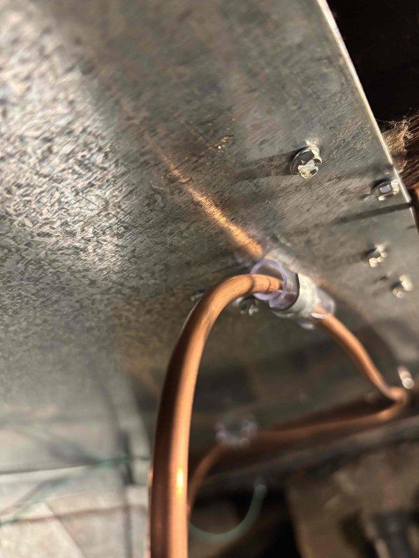 Completed inspection corrections for HVAC system following partial approval notice. Addressed three code violations: repositioned and re-secured copper water line to humidifier using proper non-galvanized fasteners and eliminated contact with return duct, corrected refrigerant liquid line clearance from galvanized clamp to prevent galvanic corrosion, and tightened loose gear clamp at furnace vent connection to ensure proper exhaust seal. All corrections documented with photographs for inspector review and final approval.