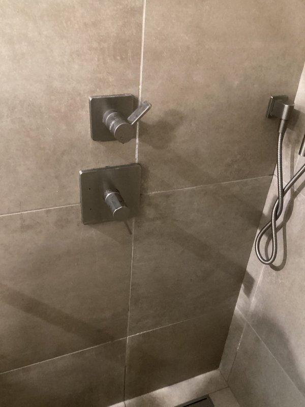 Responded to service call for leaking shower head with reported water loss of 5 gallons over 7 hours. Upon inspection, identified faulty seal in handheld shower head assembly causing continuous drip. Replaced shower head component and tested both wall-mounted control valves to ensure proper shut-off function. Verified repair eliminated leak and restored full water pressure to system.