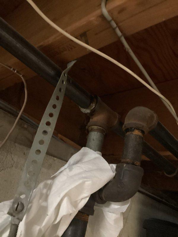 Responded to gas company-detected leak in basement gas line of 1960s-era home. Upon arrival, conducted thorough inspection of gas piping system and located source of leak at corroded black iron pipe joint. Heavily deteriorated fitting showed significant rust and oxidation at connection point, consistent with age of original installation. Confirmed leak location, documented condition of affected piping and surrounding gas line infrastructure with photographs. No odor detected at time of inspection as leak was localized to single compromised joint. Provided assessment of corroded gas line section and recommended repair options to address failed connection and prevent future issues.