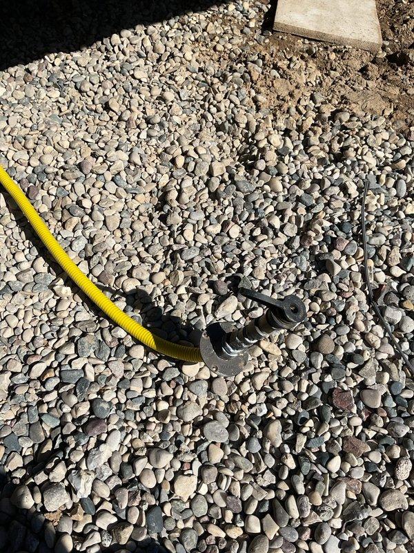 Installed gas line split to accommodate two grills at residential property. Ran flexible gas line through landscaped area and beneath deck structure, ensuring proper connection and code-compliant installation for dual grill operation.