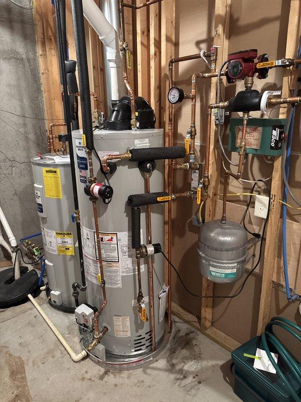 Completed installation of a 50-gallon high-output power vent water heater with comprehensive hydronic system integration. Installation included copper piping assembly with multiple isolation valves, pressure relief components, expansion tank mounting, circulation pump integration, and all necessary safety controls and pressure gauges. All connections were properly secured, system was tested for leaks and proper operation, and unit was verified to meet manufacturer specifications and code requirements.