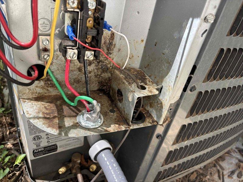 # CP-Cooling Problem

Responded to no cooling complaint on 6-year-old residential air conditioning system. Upon inspection, discovered extensive corrosion on electrical connection bracket and mounting components within outdoor condensing unit. Heavy rust deterioration was affecting electrical terminals and wire connections, compromising system operation and creating potential safety hazards. Cleaned corroded electrical connections, secured all wire terminations, and verified proper system operation. Unit restored to normal cooling function with temperature setpoint achieved.