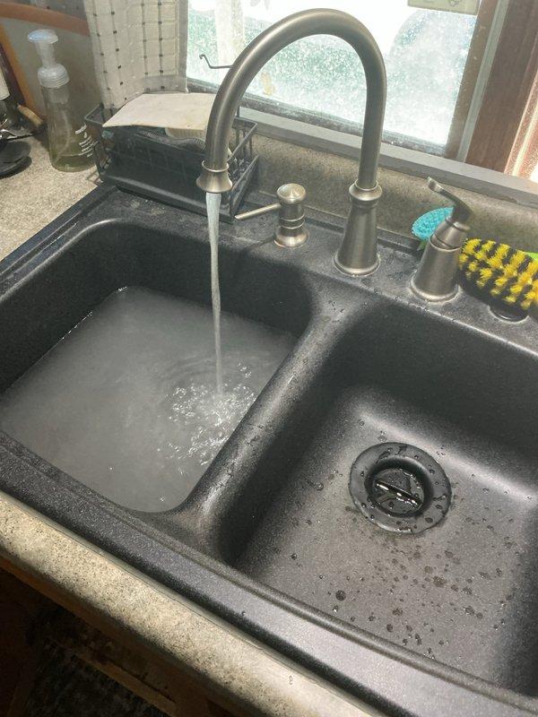 Responded to a drain clog affecting a double-basin kitchen sink that had been blocked for two days. Successfully cleared the obstruction in the affected basin, verified proper drainage and water flow through the existing PVC P-trap assembly, and confirmed no blockages in adjacent plumbing areas. System tested and restored to full functionality with no additional issues identified.