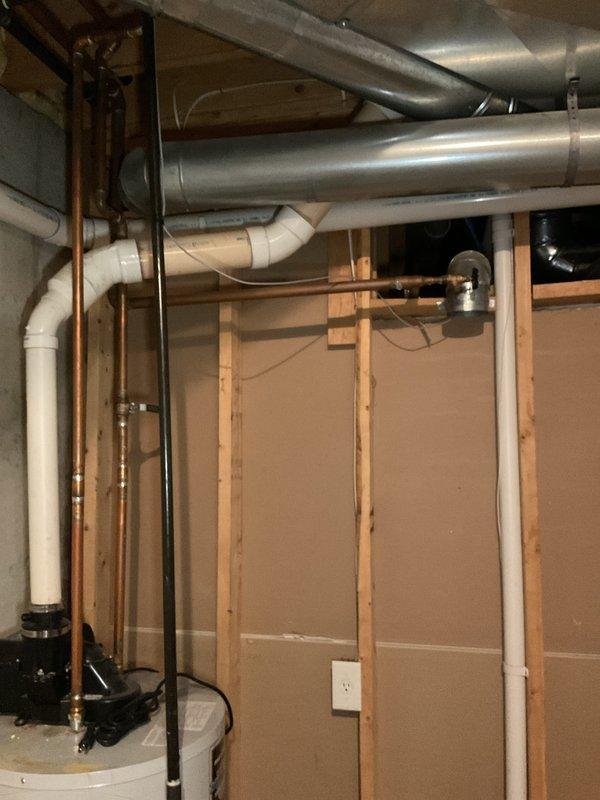 Completed water heater replacement estimate for a single-family residence with a 15-year-old existing unit located in an unfinished basement utility area. Assessed current water heater condition, documented existing plumbing connections including copper supply lines and drainage configuration, and photographed installation area showing accessible wooden stud framing and adequate clearances for replacement. Provided homeowner with replacement options and specifications for new water heater installation.