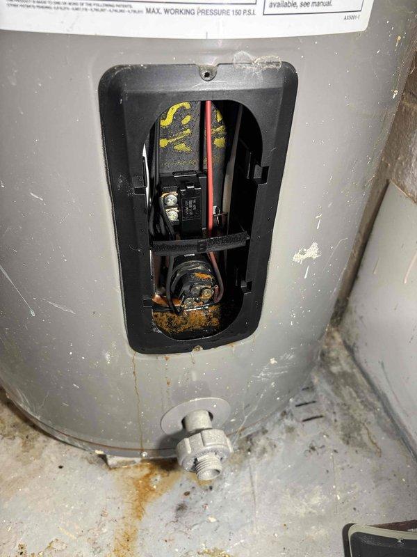 Responded to a 10-year-old residential water heater experiencing dual failure conditions: active leaking and complete loss of hot water production. Upon arrival, inspected the unit located in basement utility area and documented extensive rust staining on the concrete floor beneath the gas supply connection, indicating chronic water seepage from the lower tank section. Opened lower access panel to examine gas control valve, thermostat assembly, and burner components. Assessed internal wiring connections and gas valve operation. Based on the age of the unit, visible corrosion at the base, active leak evidence, and complete failure to heat water, determined the tank had reached end of useful service life with compromised structural integrity. Recommended complete water heater replacement as the most cost-effective and safe solution, as repairs would not address the underlying tank corrosion and leak source.