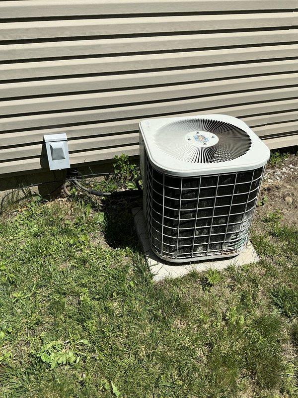 Completed estimate for residential air conditioning system. Inspected outdoor condenser unit positioned on concrete pad between building and privacy fence, documented current equipment condition and installation setup. Photographed unit configuration, electrical disconnect, and surrounding area for estimate preparation.
