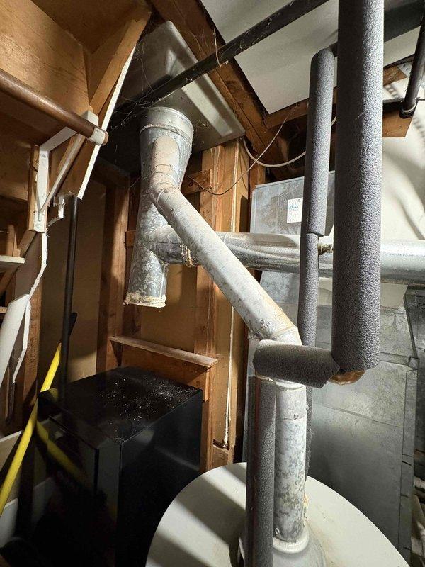 Responded to water leak investigation following home inspector's report of possible water intrusion in ductwork near furnace. Upon inspection, found significant rust and corrosion on galvanized metal ductwork at junction points and seams near furnace connection, consistent with previous moisture exposure. Confirmed prior chimney leak had been repaired several months ago. Documented extensive rust patterns on duct elbows and connector pieces with photographic evidence. Verified heating system currently operational with 17-year-old furnace and 30-year-old AC unit. No active leaking observed at time of inspection, and homeowner reported no current issues with system performance in other areas.
