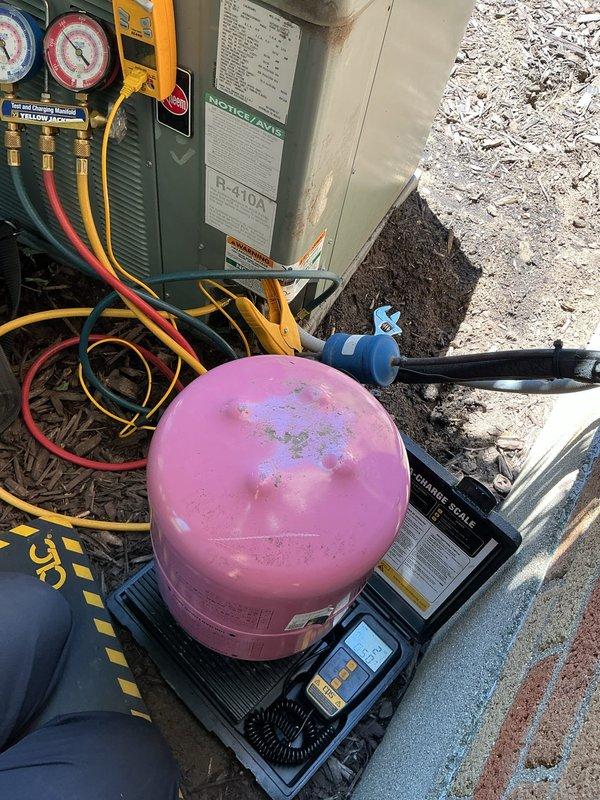 Responded to callback for refrigerant recharge on 16-year-old Rheem air conditioning system following earlier leak repair service. Upon arrival, connected manifold gauge set and verified system pressures were low due to previous refrigerant loss. Utilized refrigerant recovery equipment with digital scale to accurately measure and charge system to manufacturer specifications. Monitored system pressures using Yellow Jacket manifold gauges and digital multimeter to verify proper superheat and subcooling temperatures during charging process. System tested and confirmed operating within normal parameters with adequate refrigerant levels restored.
