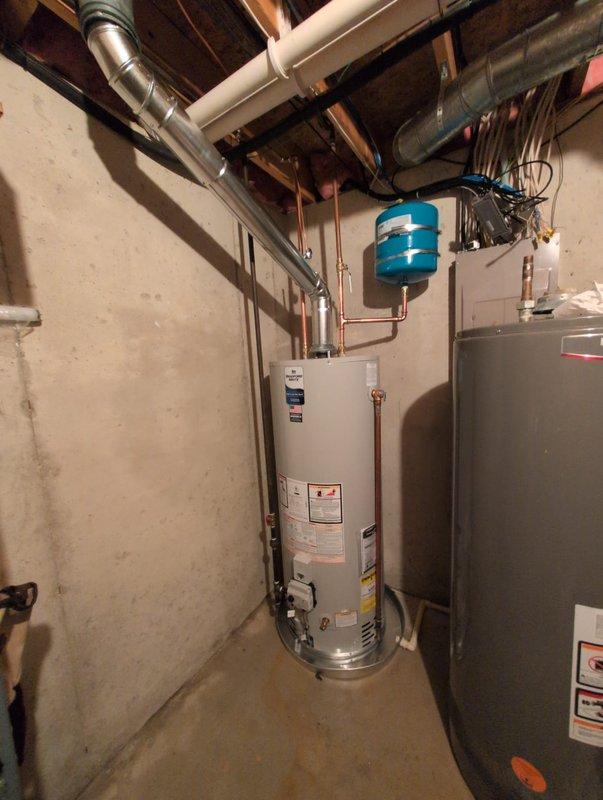 Installed a Bradford White 50-gallon natural gas water heater, model RG250T6N, with 40,000 BTU/hr input rating in residential basement utility area. Connected copper supply and discharge piping to unit, installed blue expansion tank, and verified all connections to existing plumbing system. Ensured proper clearances per manufacturer specifications and confirmed natural draft venting configuration meets code requirements.
