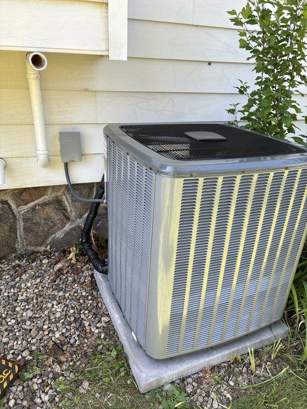 Completed full installation of new residential furnace and air conditioning system. Furnace installed in basement mechanical room with proper PVC venting and ductwork connections. Outdoor condensing unit positioned on concrete pad with electrical conduit and refrigerant lines properly connected to exterior wall. All components tested and operational upon completion.