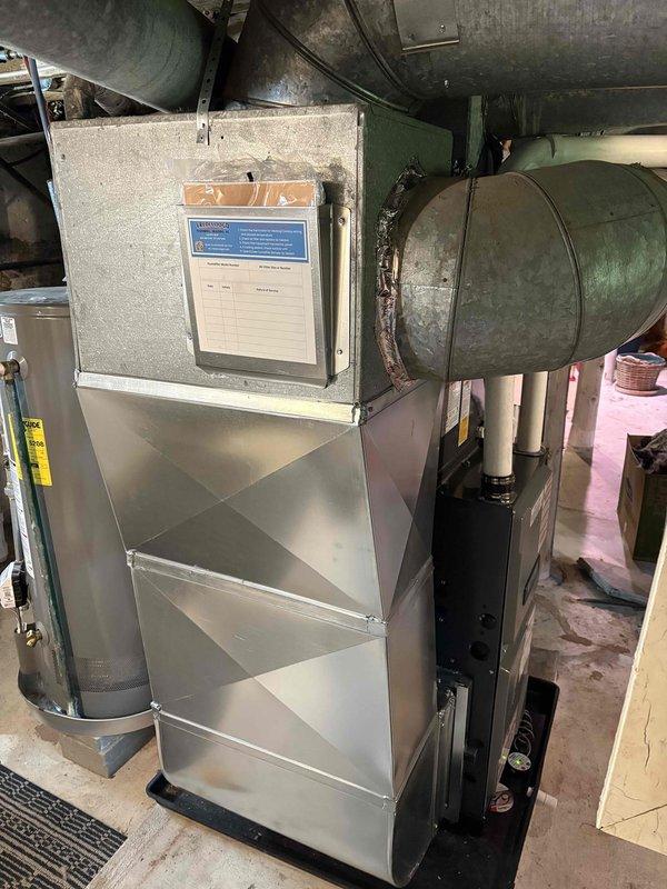Completed full installation of new residential furnace and air conditioning system. Furnace installed in basement mechanical room with proper PVC venting and ductwork connections. Outdoor condensing unit positioned on concrete pad with electrical conduit and refrigerant lines properly connected to exterior wall. All components tested and operational upon completion.