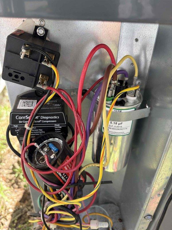 Completed annual cooling maintenance on residential air conditioning system with limited access constraints. Performed comprehensive tune-up including inspection of electrical components, contactor assembly, CoreSense diagnostics module for Copeland scroll compressor, and capacitor testing (verified 5.18 μF rating). Replaced air filter per customer request, checked all low-voltage control circuit connections and wiring integrity, and documented system condition with photos of electrical panel assembly and control components.
