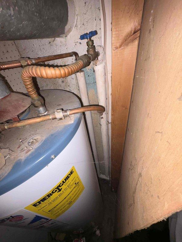 Responded to plumbing leak emergency in laundry room where frozen pipe had burst near water heater installation. Assessed damage to copper supply line, shut off water supply, and replaced damaged section of piping with new copper line and brass shutoff valve. Inspected water heater connections and surrounding plumbing for additional freeze damage, confirmed proper operation of pressure relief valve and corrugated flex connector, and restored water service to unit.