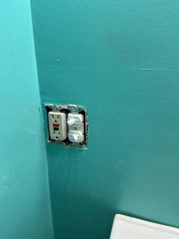 Inspected washer and dryer hookups in utility area to verify proper installation of copper water supply lines with shutoff valves and white PVC drain configuration prior to appliance delivery. Installed new bathroom sink vanity and backlit mirror in bathroom with turquoise walls, confirming GFCI outlet functionality for mirror electrical connection. All plumbing connections and electrical components verified as code-compliant and operational in this century-old home.