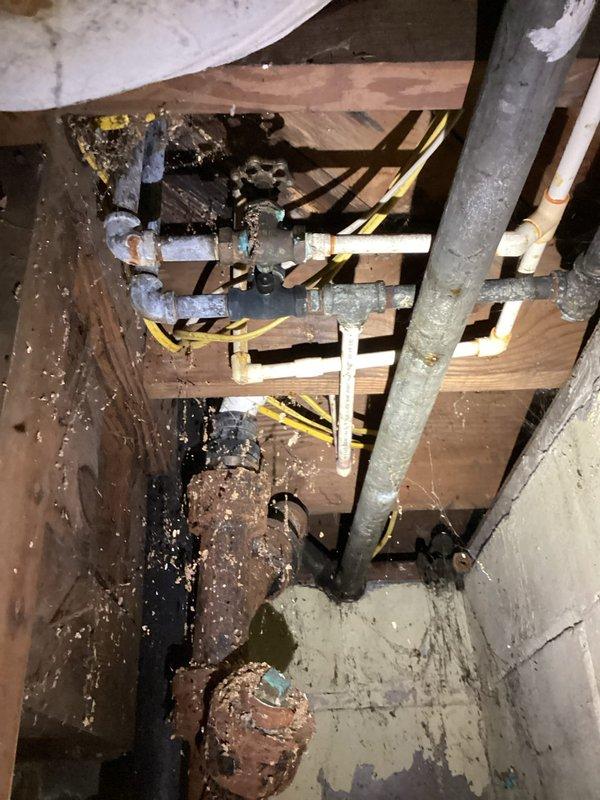Conducted comprehensive site assessment for plumbing renovation project involving shower/bathroom pipe replacement and kitchen sink relocation. Inspected crawlspace and identified deteriorated infrastructure including severely corroded water heater tank, aging copper supply lines, and existing PVC drain configuration requiring modification to accommodate new sink placement. Documented exposed wall cavities in bathroom area showing current rough plumbing layout and structural framing that will need coordination for pipe rerouting. Evaluated access points and determined scope for replacing corroded piping systems, relocating water supply and drain lines for kitchen sink repositioning, and addressing aging mechanical components in utility space. Provided detailed photographic documentation of existing conditions to support accurate material estimation and project planning.